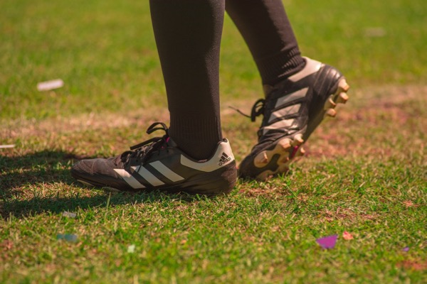 Sport injury treated by Hosford Health Clinic osteopath; athlete with football boots on